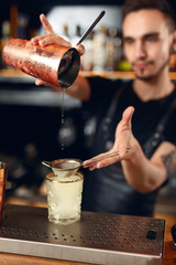 Fototapeta na wymiar Cocktail Bar. Bartender Making Cocktails, Pouring Drink In Glass