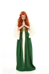 Obraz na płótnie Canvas full length portrait of red haired girl wearing long green medieval gown. standing pose, isolated on white studio background.
