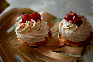 Airy and delicious meringue Anna Pavlova on a gold leaf monstera. Culinary art