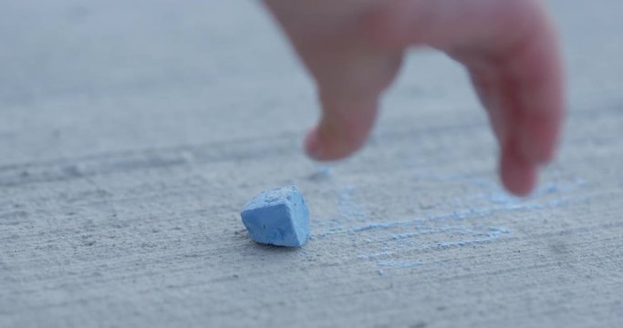Sidewalk chaulk gets dropped on sidewalk - close up