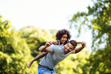 Portrait of young father carrying his daughter on his back