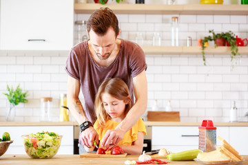 Photo of father with little daughter cooking lunch