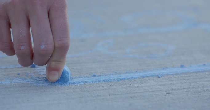 Hand holding sidewalk chaulk close up