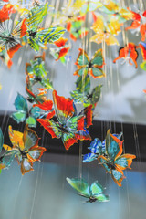 Glass colorful butterflies hang in the shop window