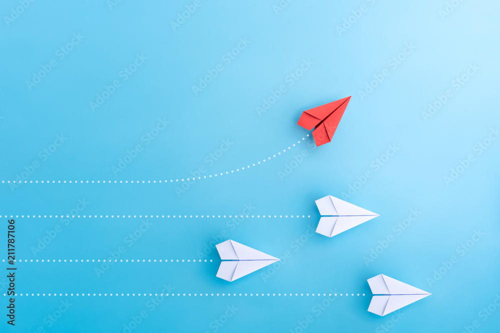 Wall mural group of paper plane in one direction and with one individual pointing in the different way. busines