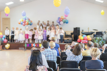 Children's holiday in kindergarten. Children on stage perform in front of parents. image of blur kid 's show on stage at school , for background usage. Blurry