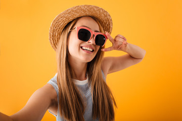 Pretty young blonde woman in summer hat and sunglasses