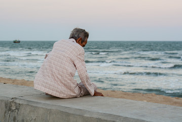 A man sitting and looking at the sea