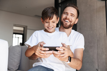 Fototapeta premium Handsome bearded man indoors at home with his son
