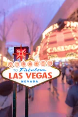 Poster Im Rahmen Berühmtes Las Vegas-Schild mit unscharfem Stadtbild © vichie81