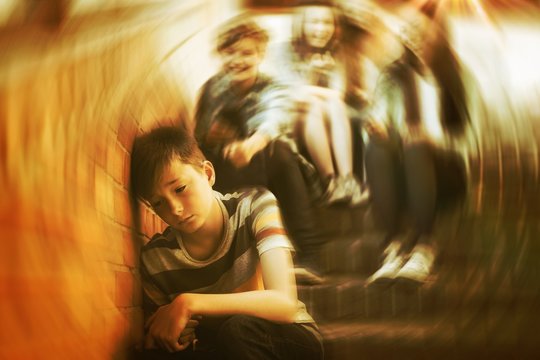 School friends bullying a sad boy in school corridor