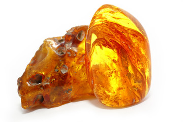 Amber. Two unusually beautiful transparent piece of yellow amber on a white background. Frozen resin with patterns and inclusions inside. A natural mineral for jewelers. Crystal. Sun Stone