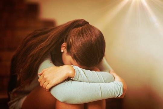 Sad schoolgirl sitting alone on staircase