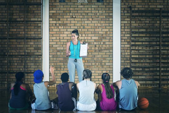 Female coach mentoring high school kids - Powered by Adobe