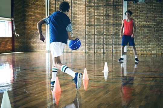 High school boys practicing football using cones for dribbling