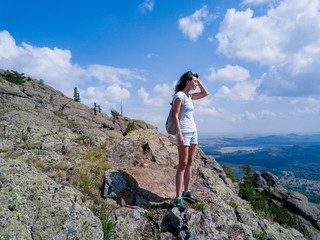 Brave girl standing on the edge of the huge stone