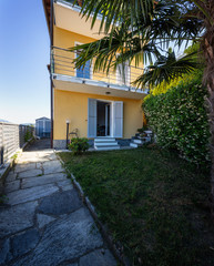 Fototapeta na wymiar Exterior of yellow villa with driveway