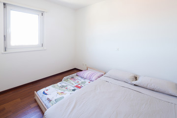 Bedroom with window and bed on the ground