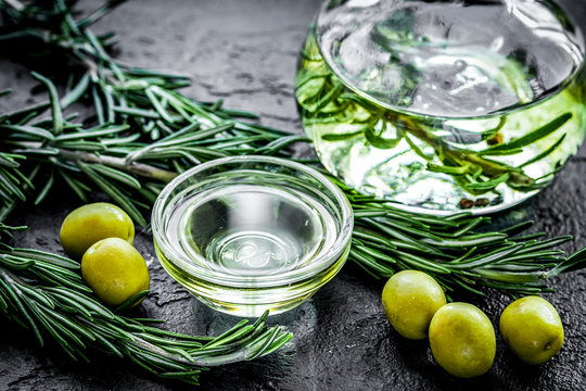 jar with oil with olives on stone table background