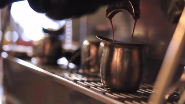 Brewing hot espresso behind the counter in a coffee shop