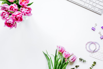 Spring flowers on workdesk at home white background top view moc