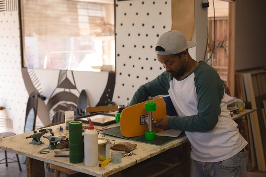 Man making skateboard in workshop