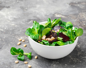 Fresh salad from the sprouts of a young green lettuce and beets in a white bowl. The concept of a...