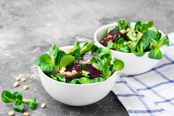 Fresh salad from sprouts of young green lettuce and beets in white bowls. The concept of vegetarianism.