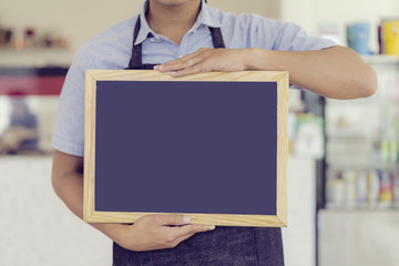 Asian waiters showing food menu with wood frame in restaurant.;