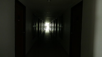 dark hotel corridor with light at the end