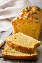 Homemade pumpkin bread on wooden table.