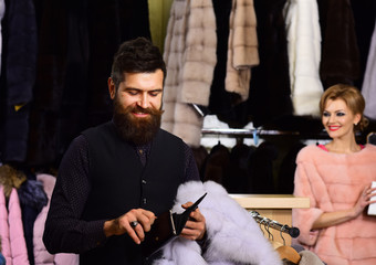 Woman in pink fur coat with man. Couple shopping concept.
