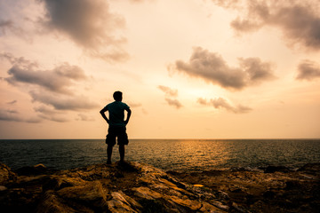 Fototapeta na wymiar man standing on the rocks at the sea