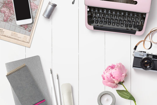 styled feminine desk background with various writing supplies, vintage camera and pink peony - top view, copyspace for your text