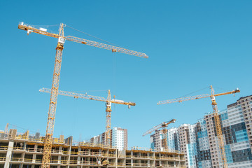 Side with cranes against blue sky