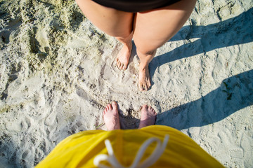 couple legs overhead view on sand beach. summer time