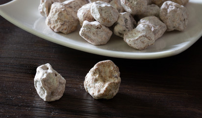 Dried Plums salted in white dish and out of dish on brown wooden