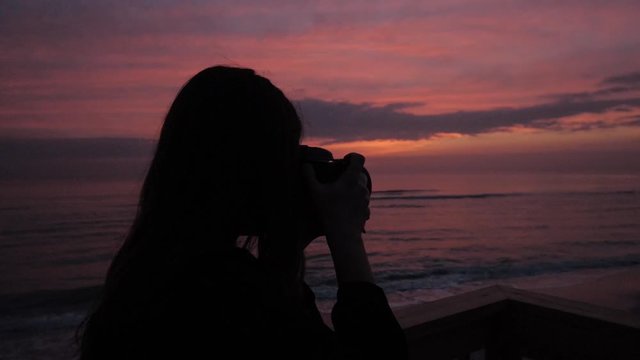 Woman taking Pictures of the Beach Sunset