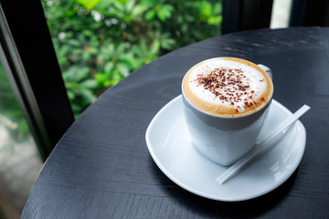 coffee in white cup on the black wooden table