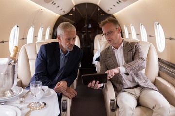 Businesspeople discussing over digital tablet