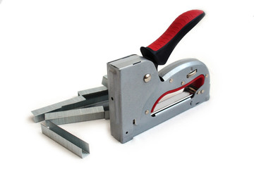 a construction stapler and staples on a white isolated background