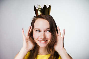 happy young girl smiling, wearing a yellow dress, wearing a gold crown, a good mood