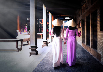 Vietnam woman wearing Ao Dai culture traditional at old temple at Ho Chi Minh in Vietnam,vintage style,travel and relaxing concept.
