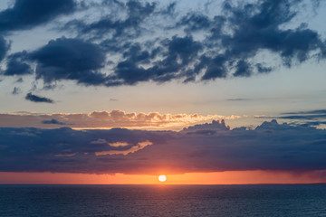 beautiful dramatic sunset over the sea with massive clouds. toned
