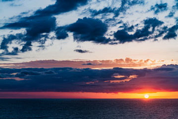 Fototapeta na wymiar beautiful dramatic sunset over the sea with massive clouds. toned