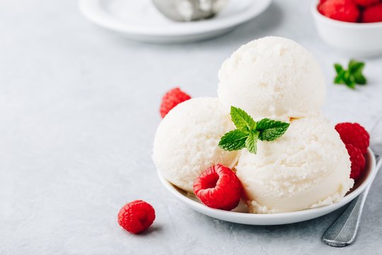 Vanilla ice cream with fresh raspberries and mint leaves