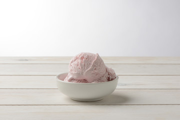 Helado de fresa sobre fondo de madera blanca