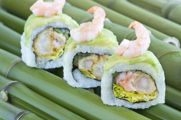 Sushi with shrimps on green bamboo sticks