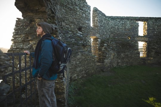 Male hiker standing in old ruin at countryside