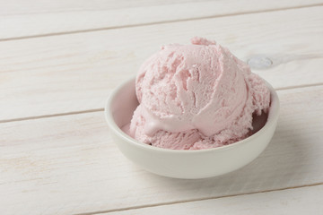 Helado de fresa sobre fondo de madera blanca